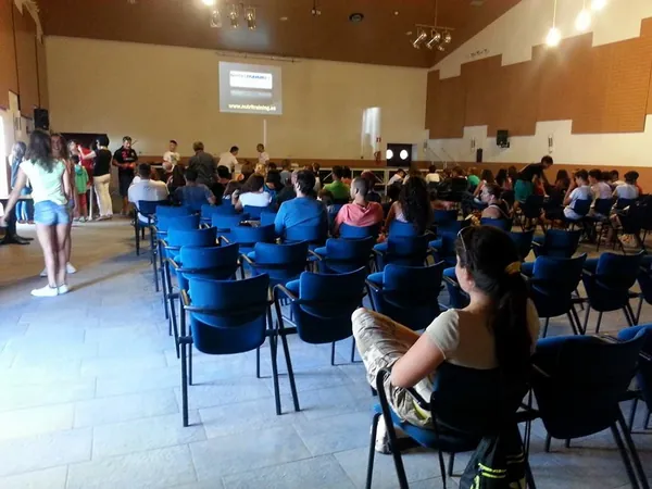 Público sentado en una sala escuchando una charla en un club deportivo
