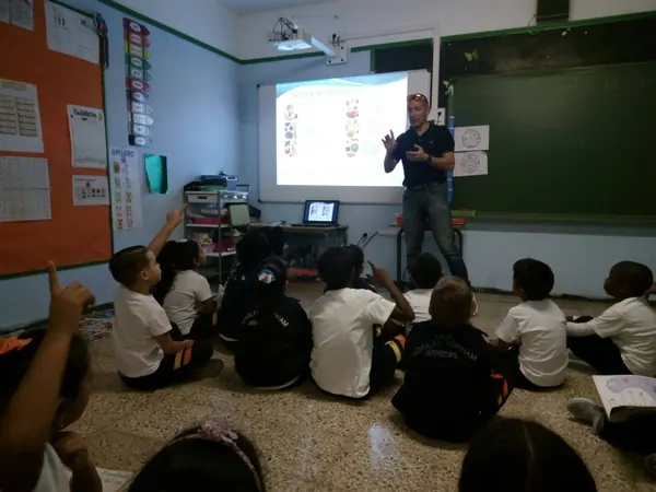 Fran Delgado dando una charla de nutrición a un grupo de niños en un colegio