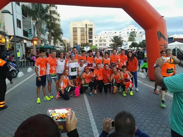 El equipo de Nutritraining, con la equipación naranja, posando bajo el arco de meta de una carrera