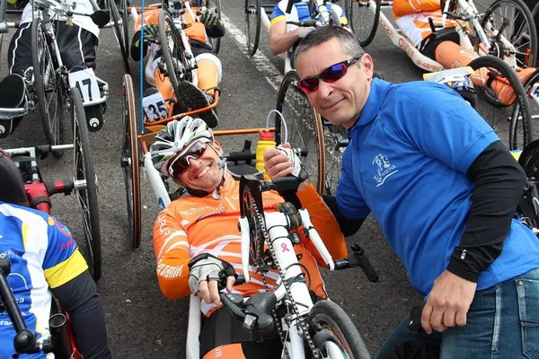 Fran Delgado junto a un deportista en handbike en la zona de transición de un triatlón