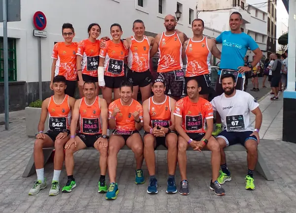 Triatletas del equipo Trimakina sentados en un banco con sus dorsales
