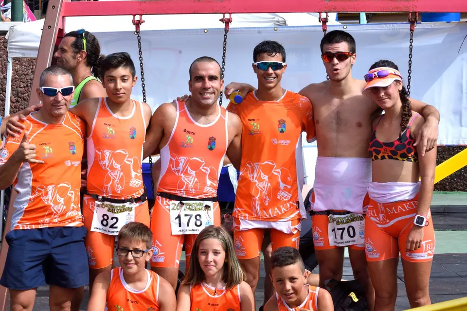Deportistas del equipo Trimakina, mayores y pequeños, con la equipación naranja y sus dorsales