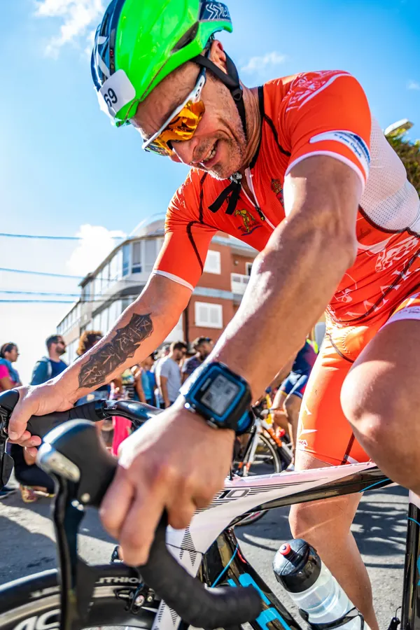 Ciclista con la equipación naranja sonriendo durante una prueba