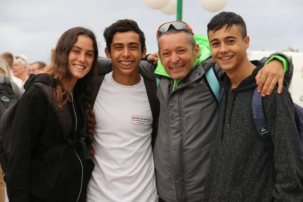 Fran Delgado abrazado a tres jóvenes deportistas de Nutritraining