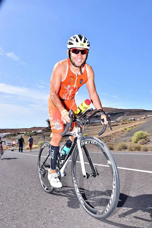 Ciclista entrenando en una carretera entre volcanes de Lanzarote