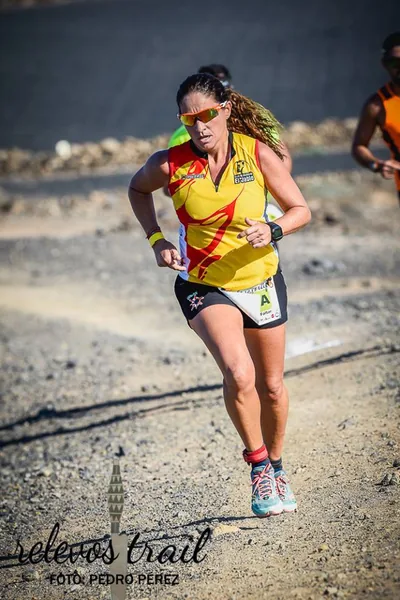 Corredor de trail con la equipación naranja en plena bajada